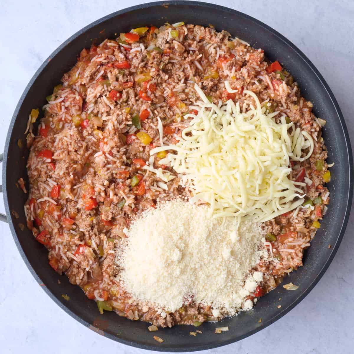 Shredded mozzarella and grated parmesan cheeses added on top of the stuffed pepper filling before mixing.