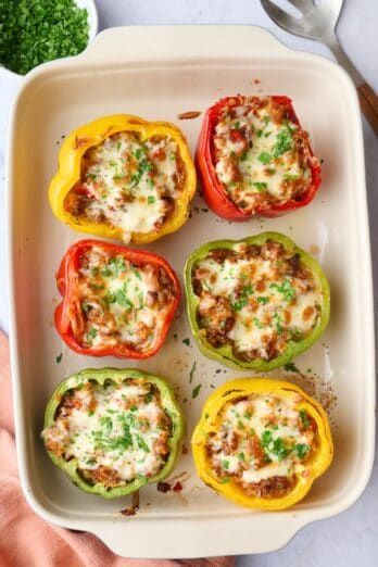 The best stuffed peppers recipe made with ground beef, white rice, tomatoes and cheese in a baking dish.