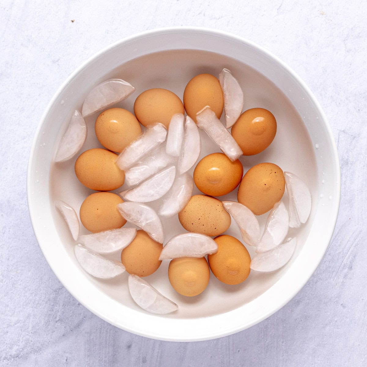 Whole eggs in a bowl of ice after cooking in a pressure cooker.