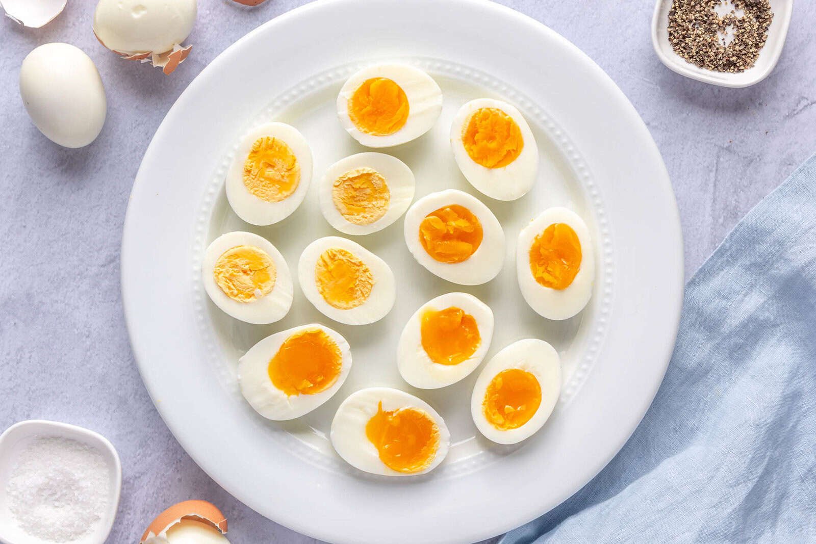 Instant pot hard boiled eggs on a plate after cutting in half at varying cook temps.