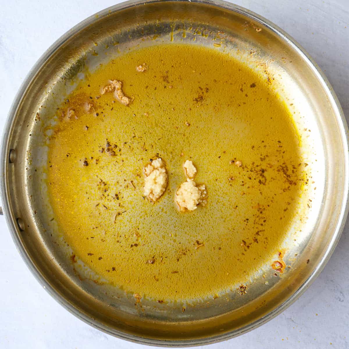 Minced garlic added to pan after removing chicken.