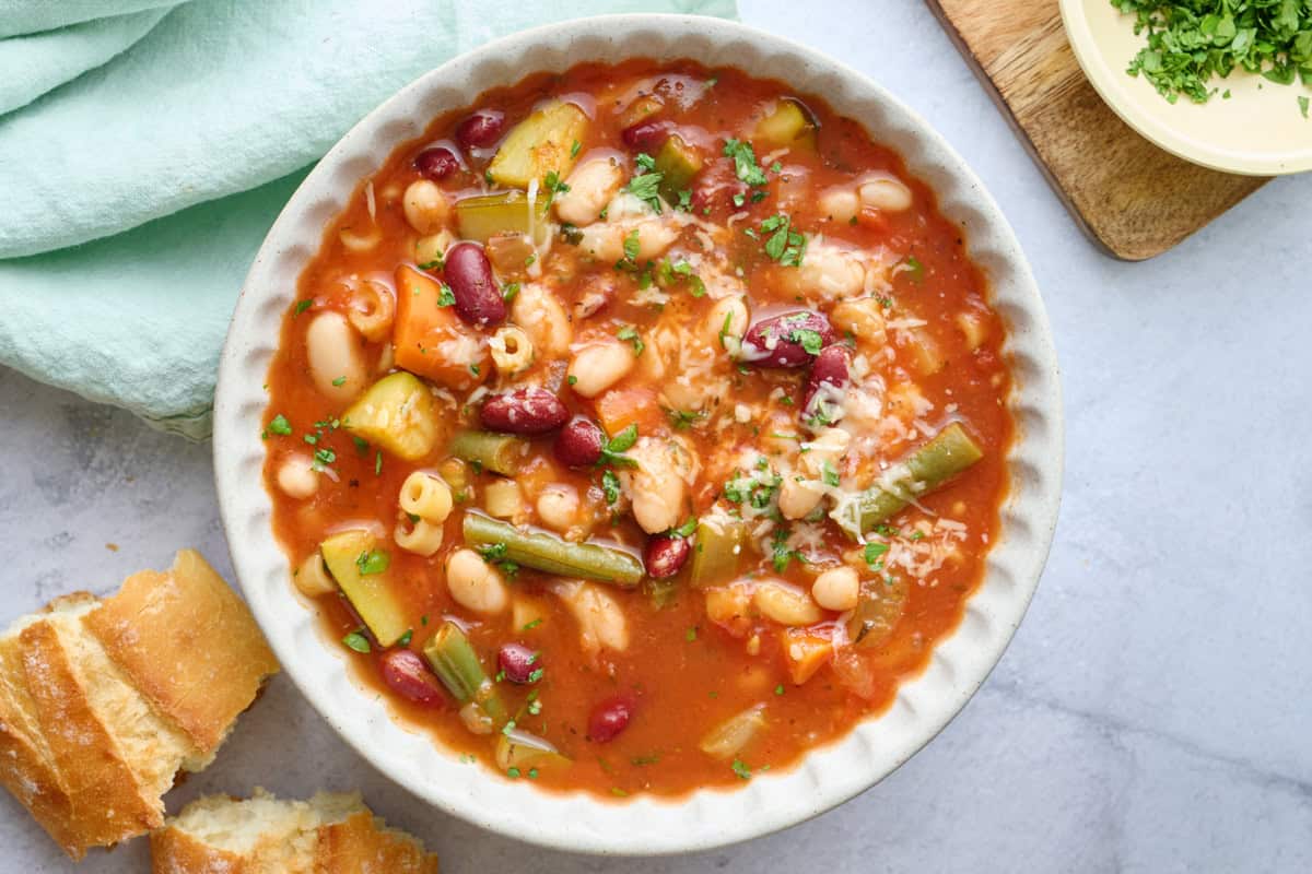 Warm bowl of minestrone soup with zucchini and green beans.