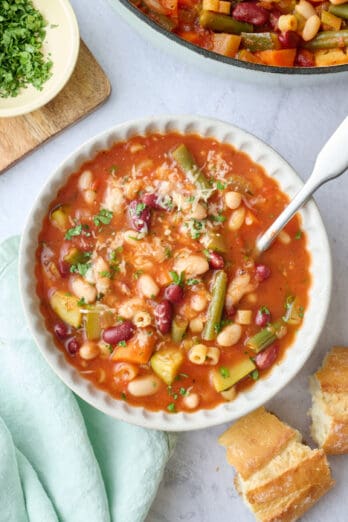 Bowl of minestrone soup with parmesan cheese on top.
