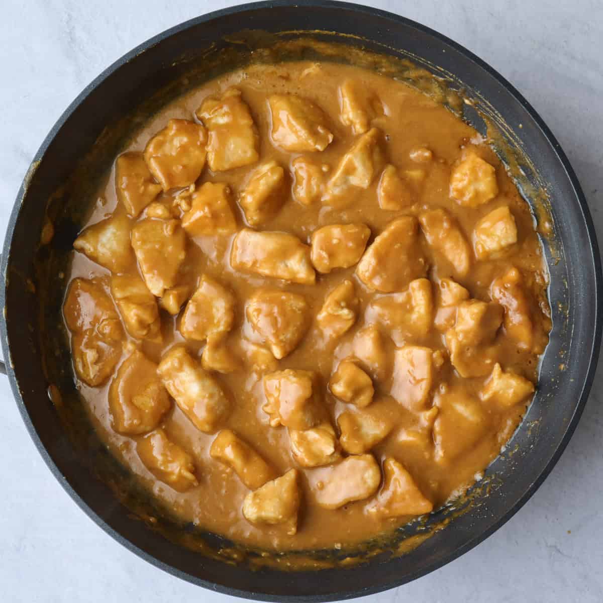 Peanut butter chicken after tossing and simmering until glossy and sauce clings to chicken.