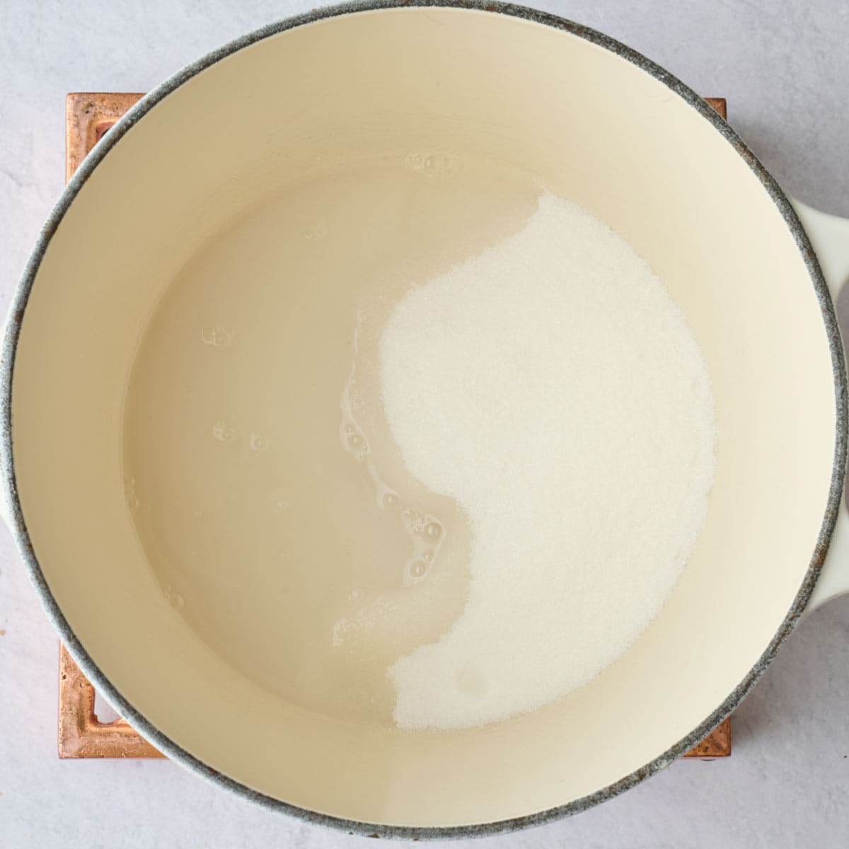 Sugar and water in a pot before dissolving for candy recipe.