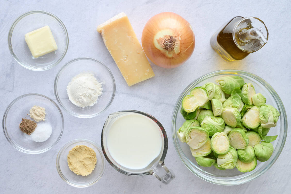 Ingredients for casserole recipe: butter, spices, flour, parmesan cheese, milk, onion, oil, and brussel sprouts.