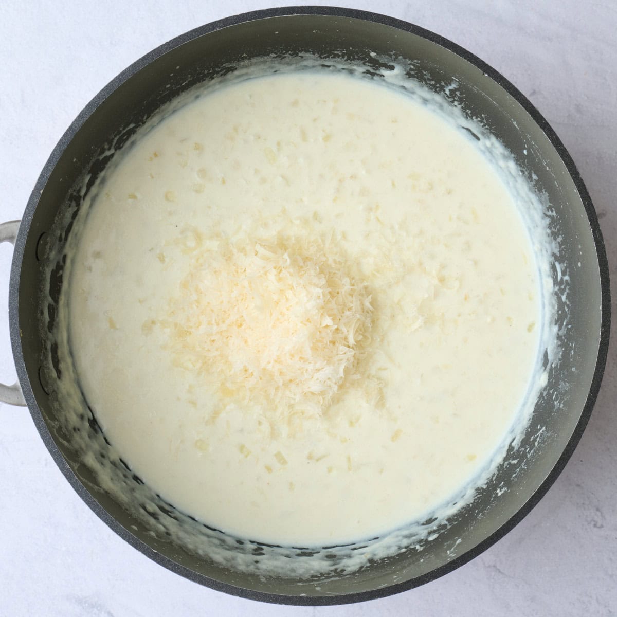 Shredded parmesan cheese added on top of creamy sauce.