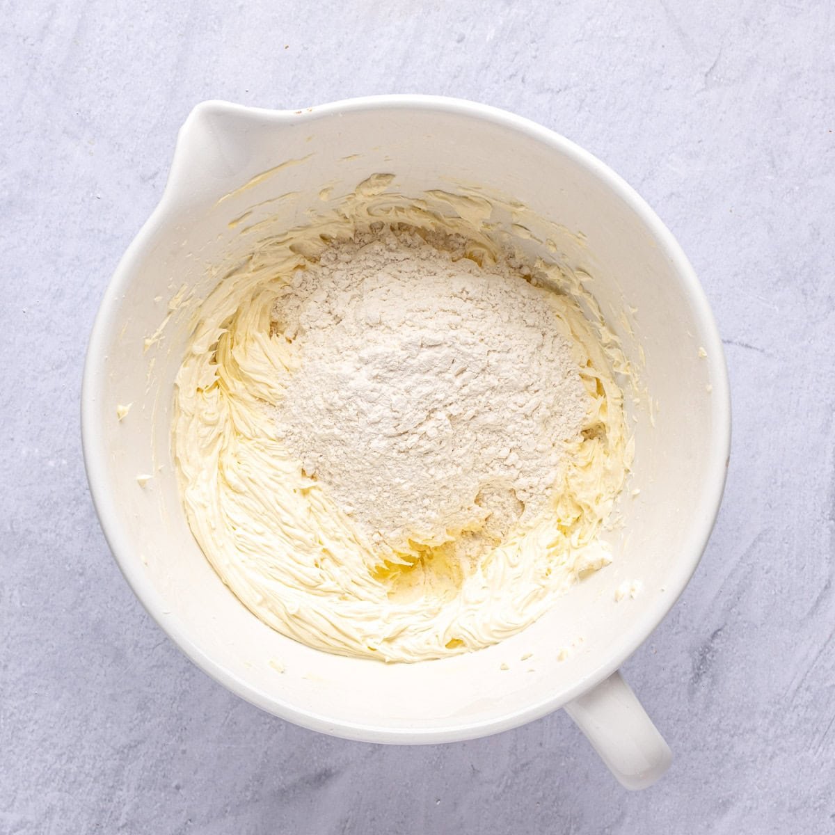 Part of the flour added to the creamed butter and sugar before combining.