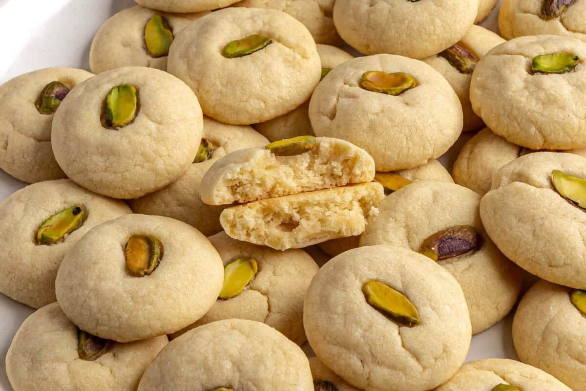 Homemade ghraybeh cookies on a plate made with pistachios and rose water.