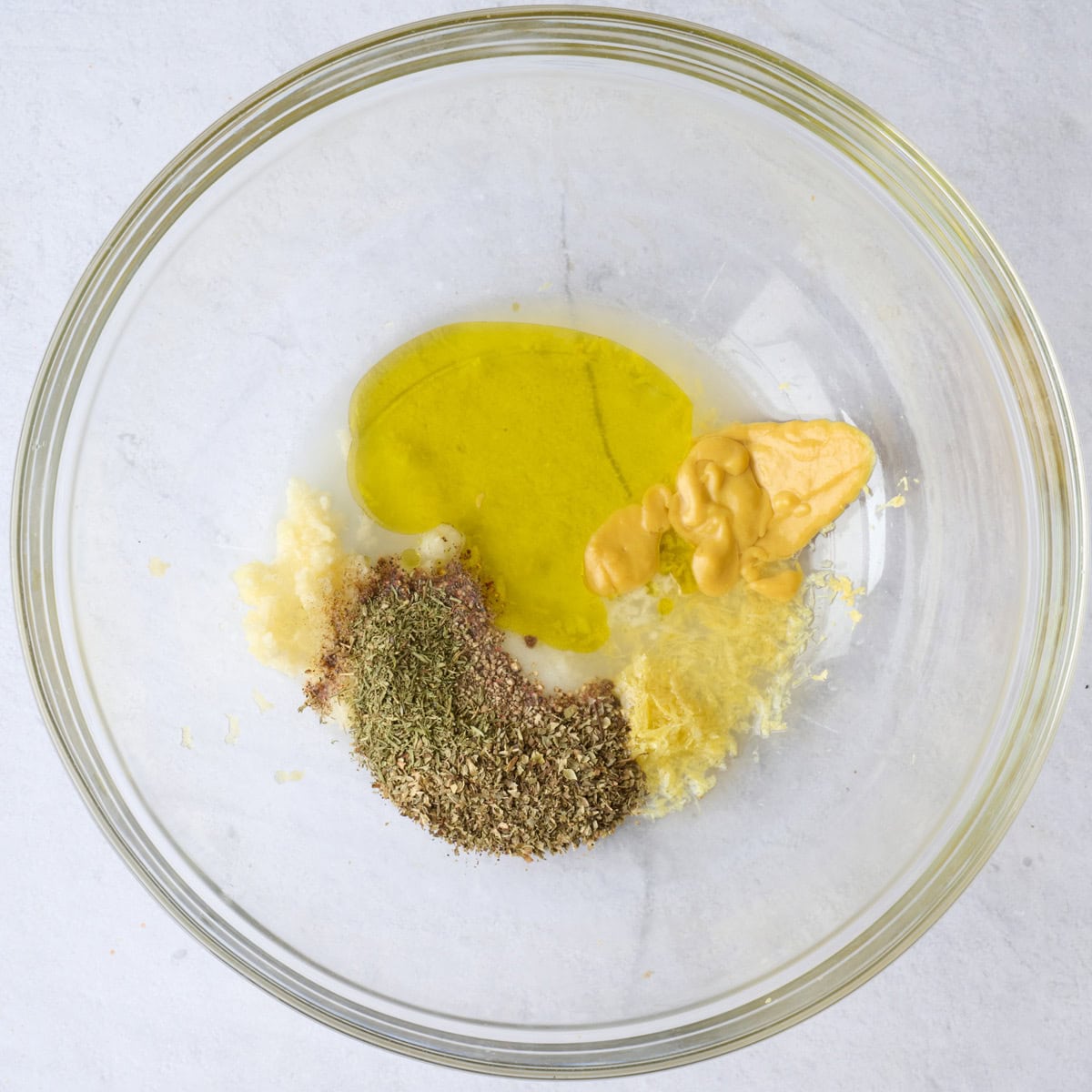 Greek marinade ingredients for chicken recipe in a bowl before mixing.