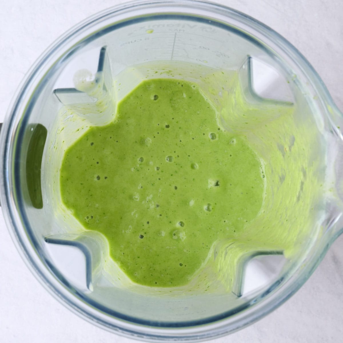 Smoothie ingredients after blending into a smooth creamy green drink.