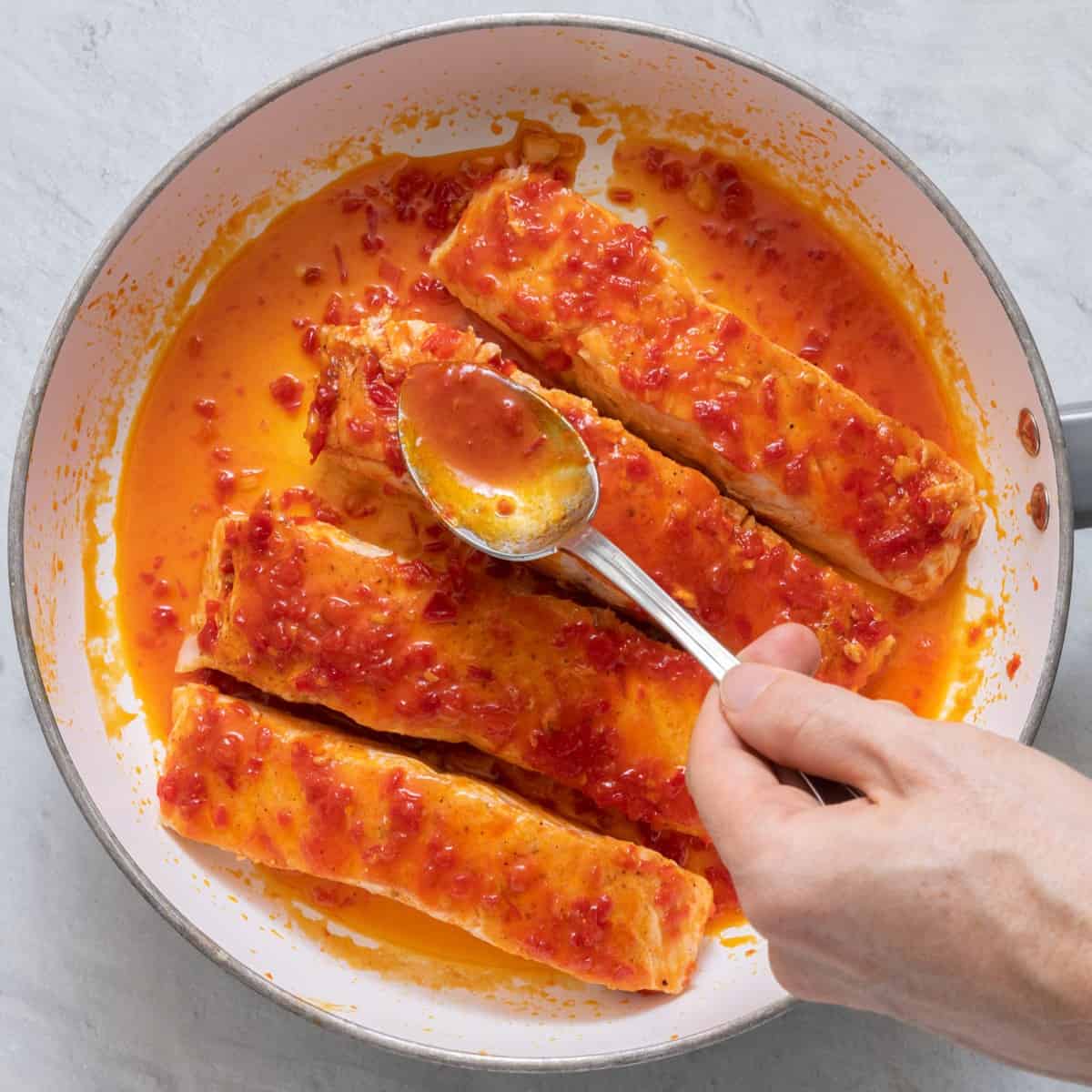 Coating pan seared salmon fillets with honey harissa sauce.