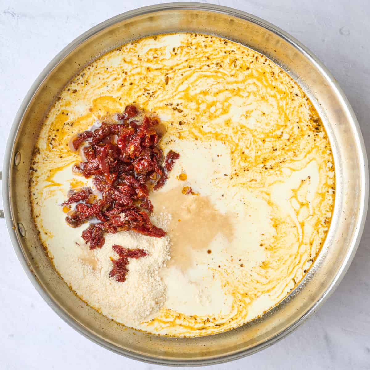 Cream, sun-dried tomatoes and parmesan added to sauteed garlic for pasta sauce.