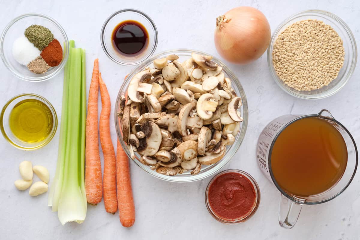 Ingredients for soup recipe: mushrooms, barley, broth, tomato paste, onion, carrots, celery, garlic, oil, soy sauce, and seasonings.