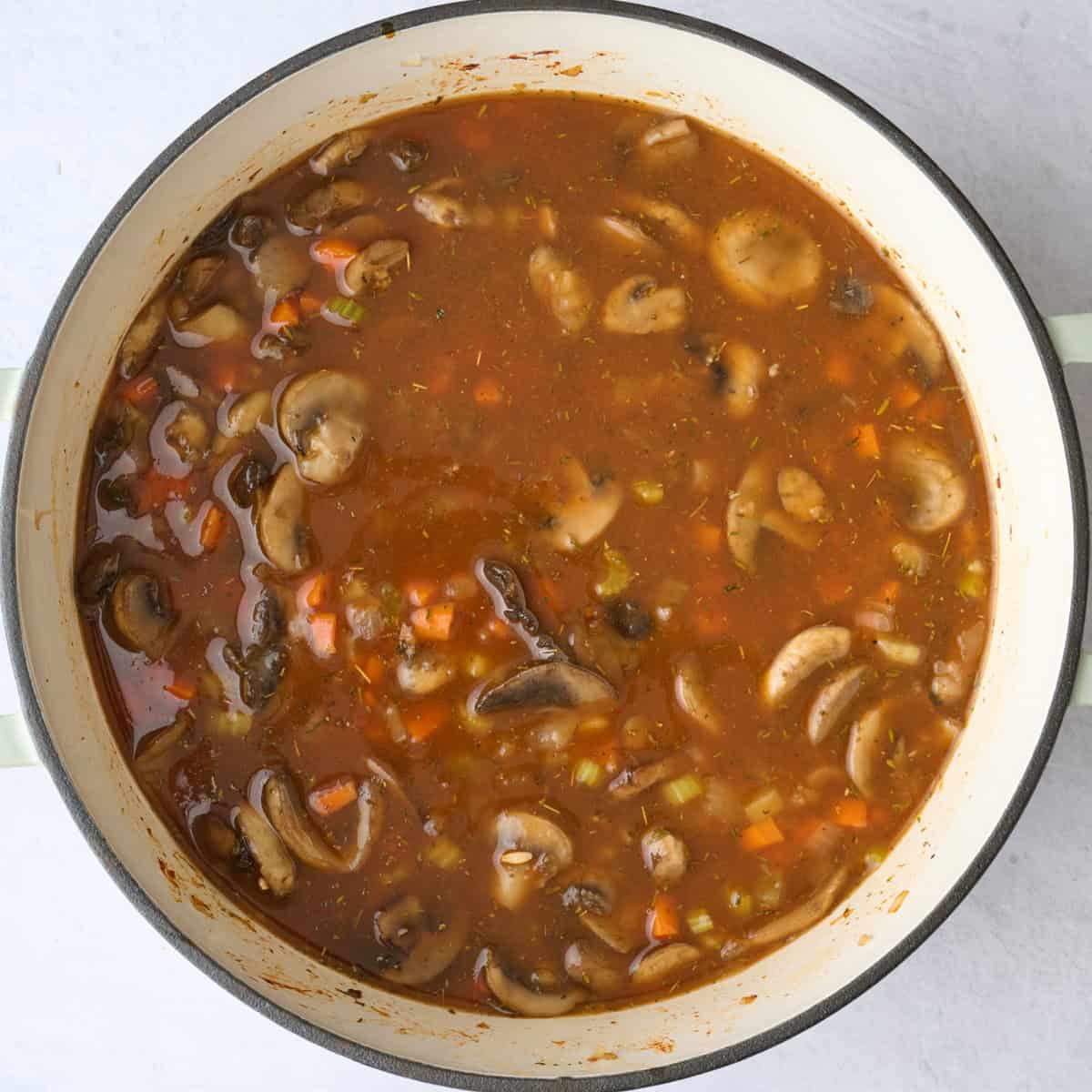 Vegetarian mushroom soup in a pot before barley is cooked.