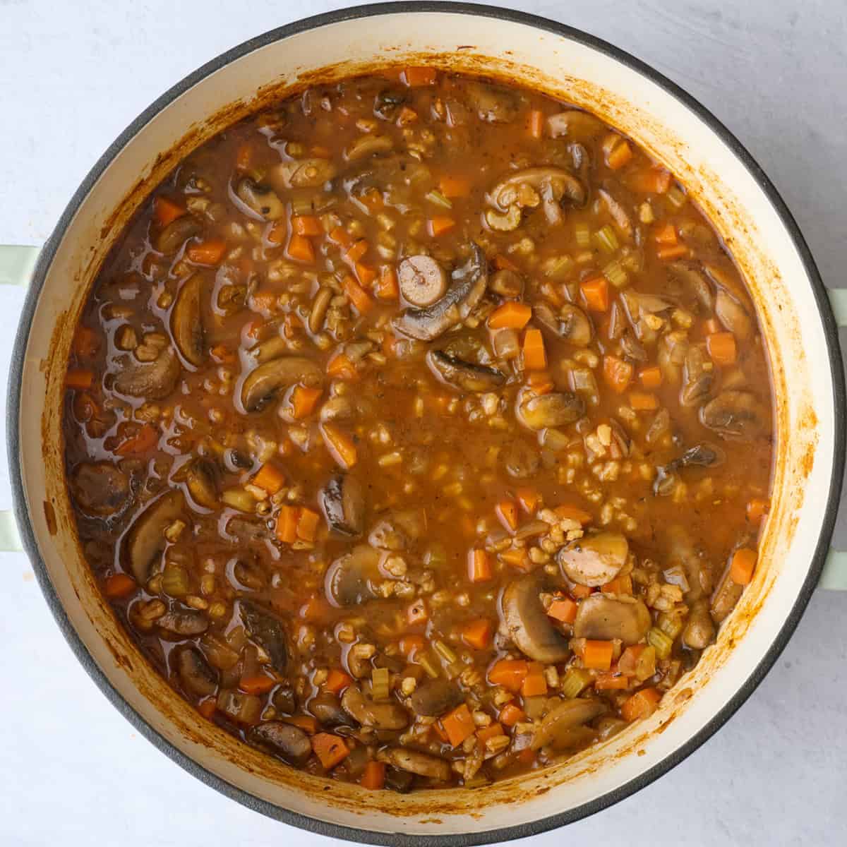 Mushroom barley soup after cooking in a pot with thickened broth.