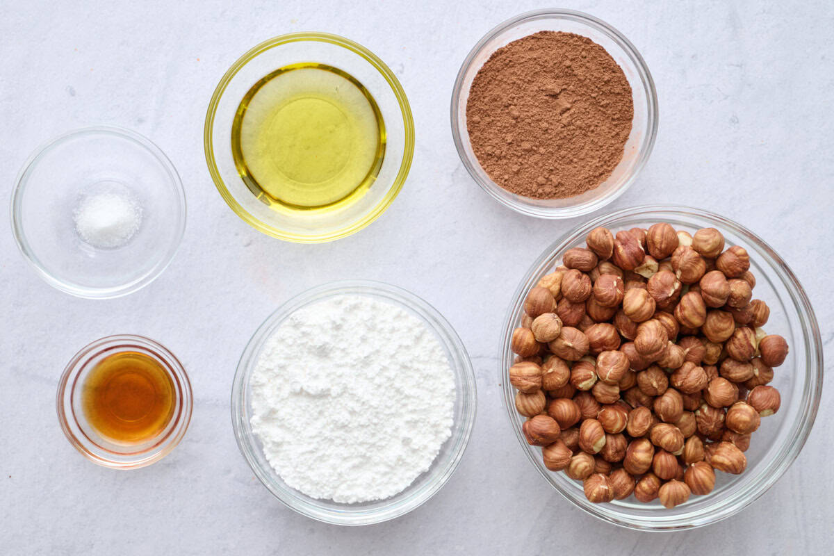 Ingredients for homemade spread recipe: hazelnuts, cocoa powder, oil, powdered sugar, vanilla and salt.