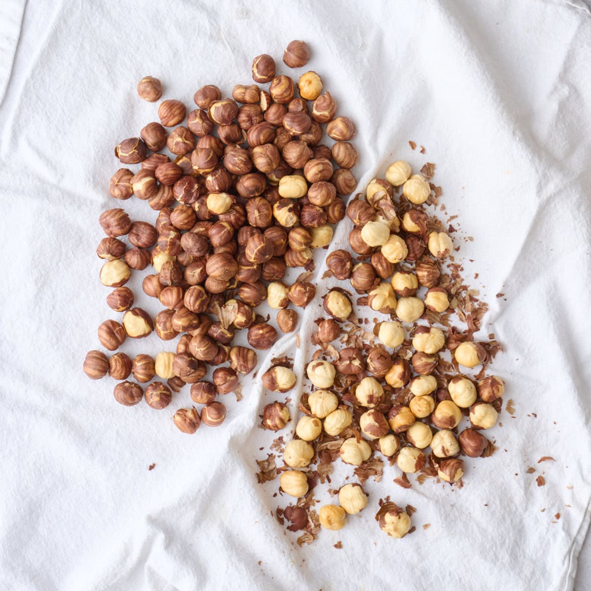 Roasted hazelnuts on a clean kitchen towel after rubbing off some o the skins.