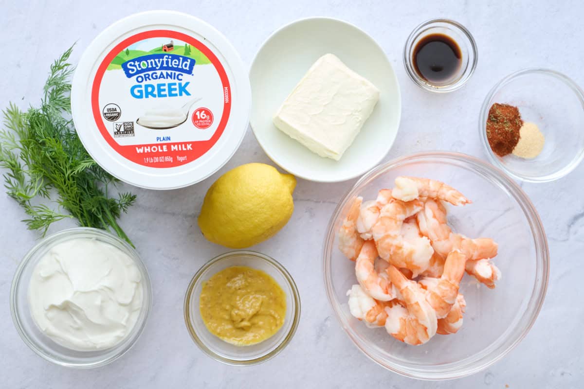 Ingredients for dip recipe; Stonyfield whole milk Greek yogurt, cooked shrimp, cream cheese, lemon, Dijon mustard, Worcestershire sauce, Old Bay seasonings, garlic powder, and fresh dill.