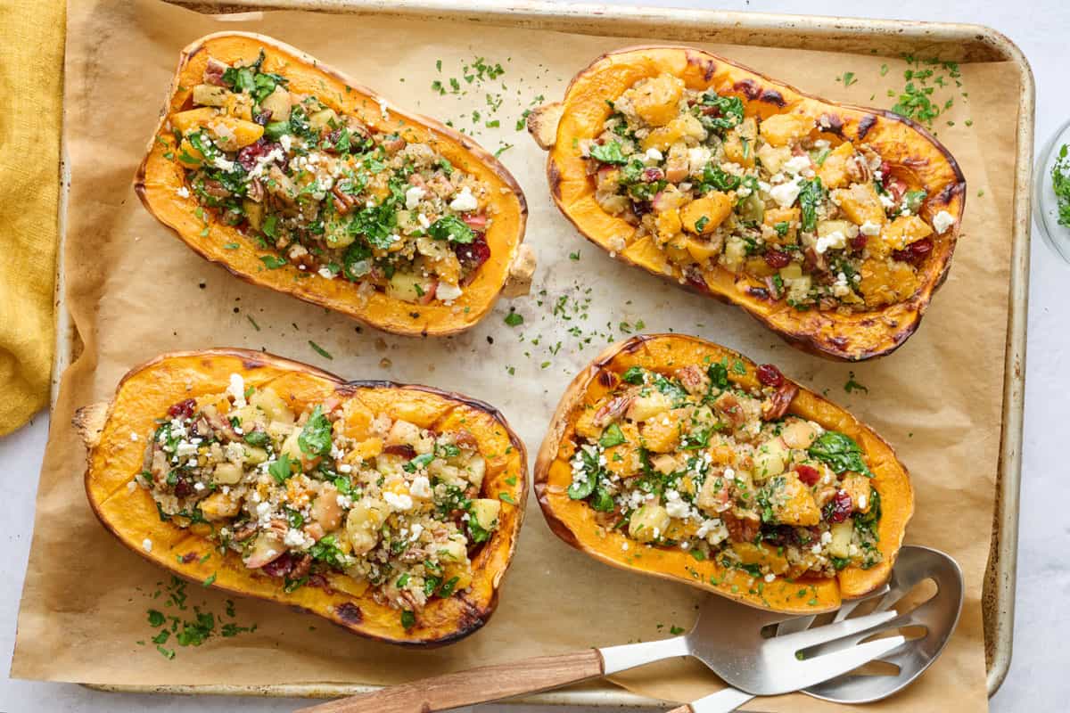 Quinoa, pecan, cranberry, feta, and spinach stuffed butternut squash on a sheet pan.