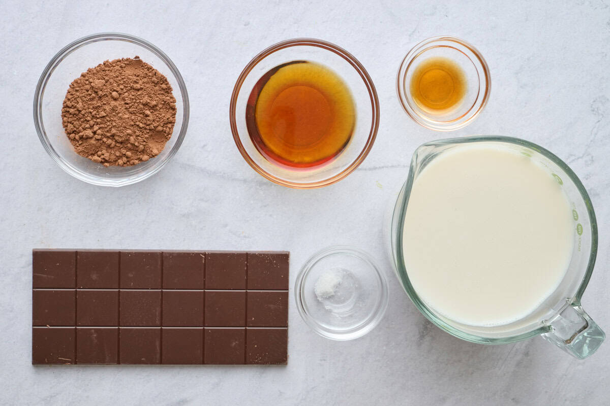 Ingredients for hot chocolate recipe: unsweetened cocoa powder, dairy free dark chocolate bar, maple syrup, vanilla extract, salt, and almond milk.