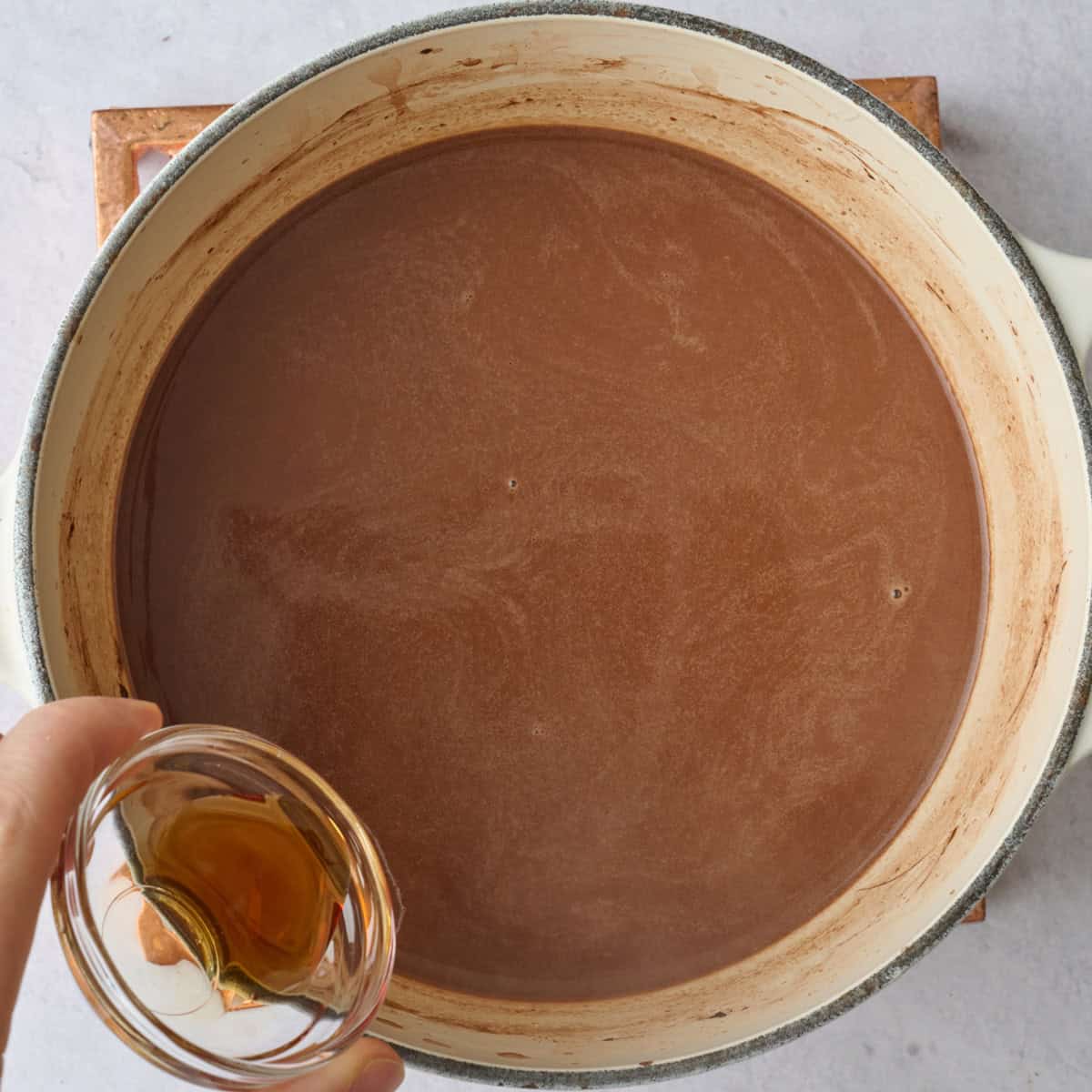 Vanilla being added to warm almond chocolate milk mixture.