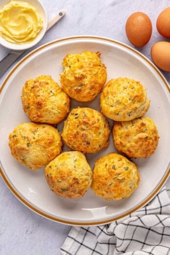 Easy breakfast biscuits made with cheddar cheese, eggs, and chives on a plate.