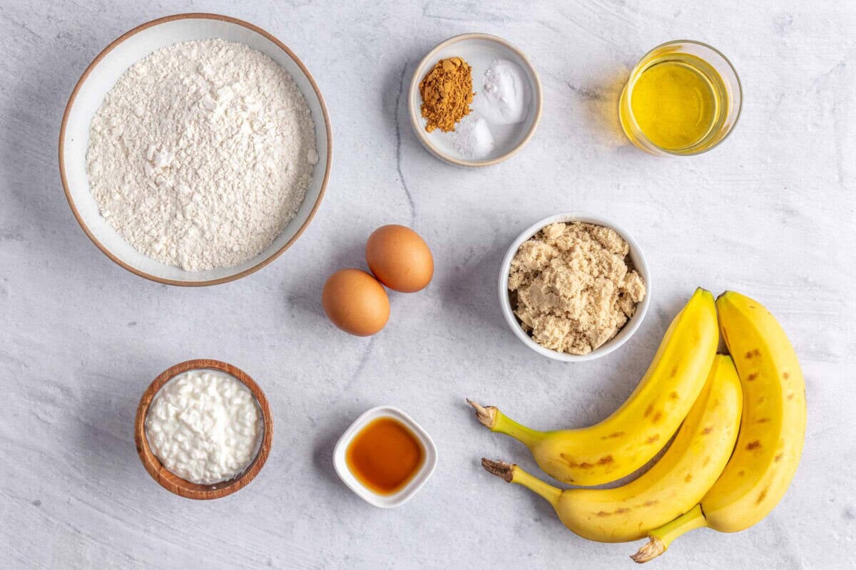 Ingredients for quick bread recipe: flour, cottage cheese, eggs, vanilla, brown sugar, cinnamon, baking powder, salt, oil, and bananas.