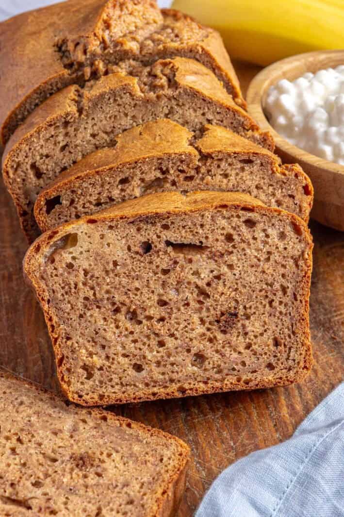 Best cottage cheese banana bread cut into thick slices on a cutting board showing inside texture.