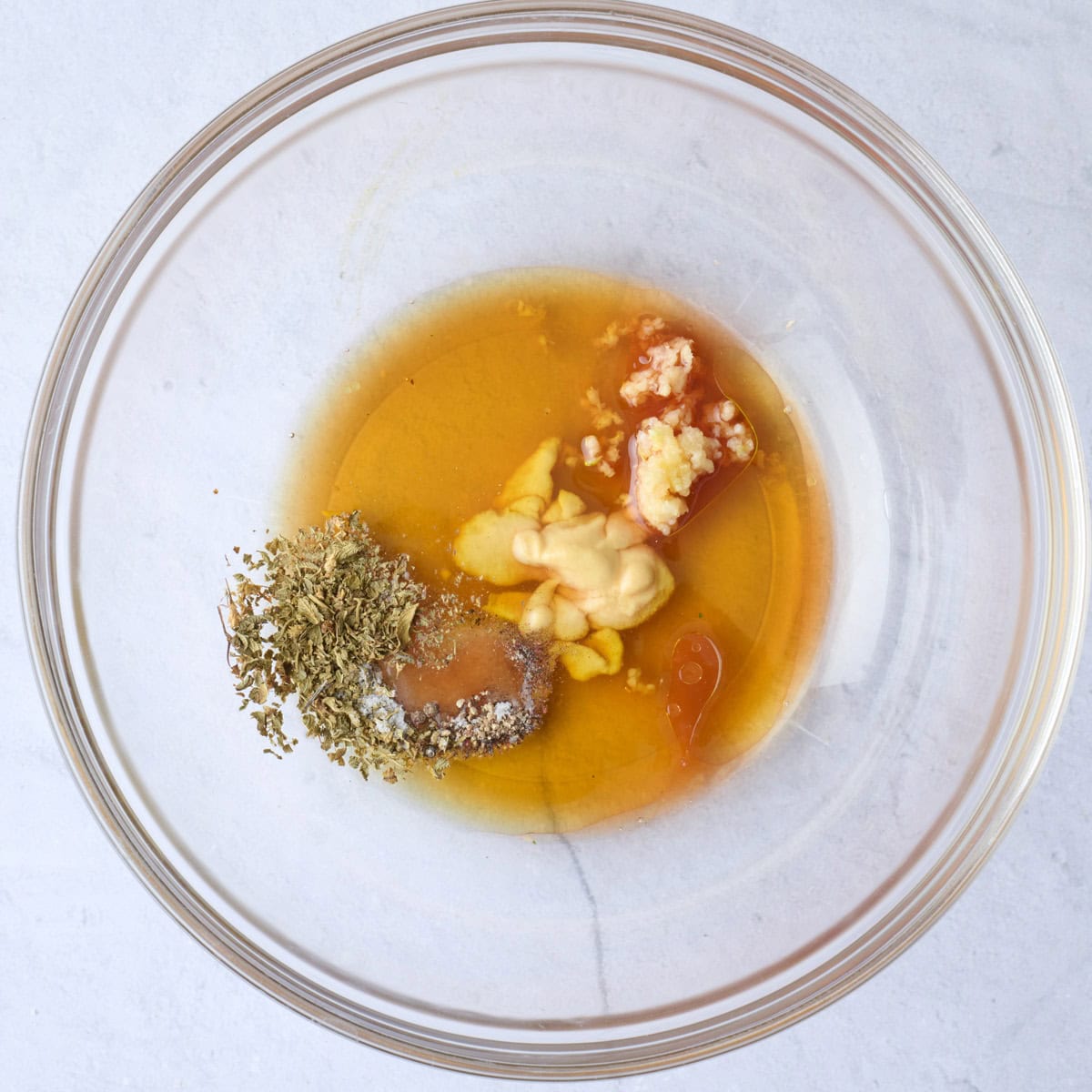 Italian dressing ingredients in a bowl before combining.