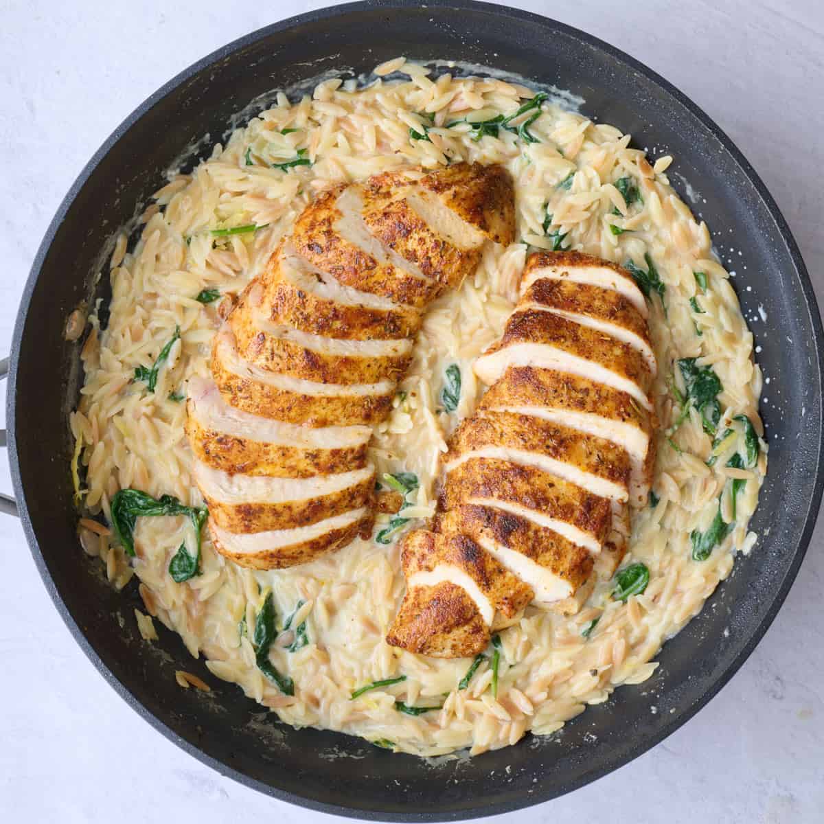 Sliced chicken breast added on top of creamy orzo before serving.