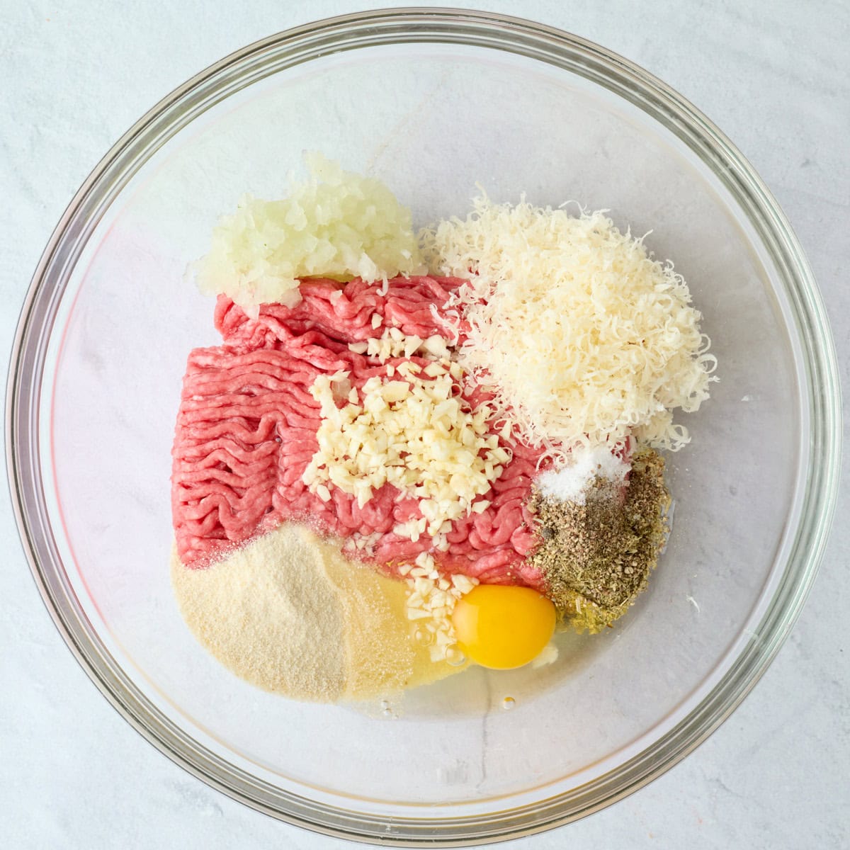 Ground beef meatball ingredients in a bowl before combining.