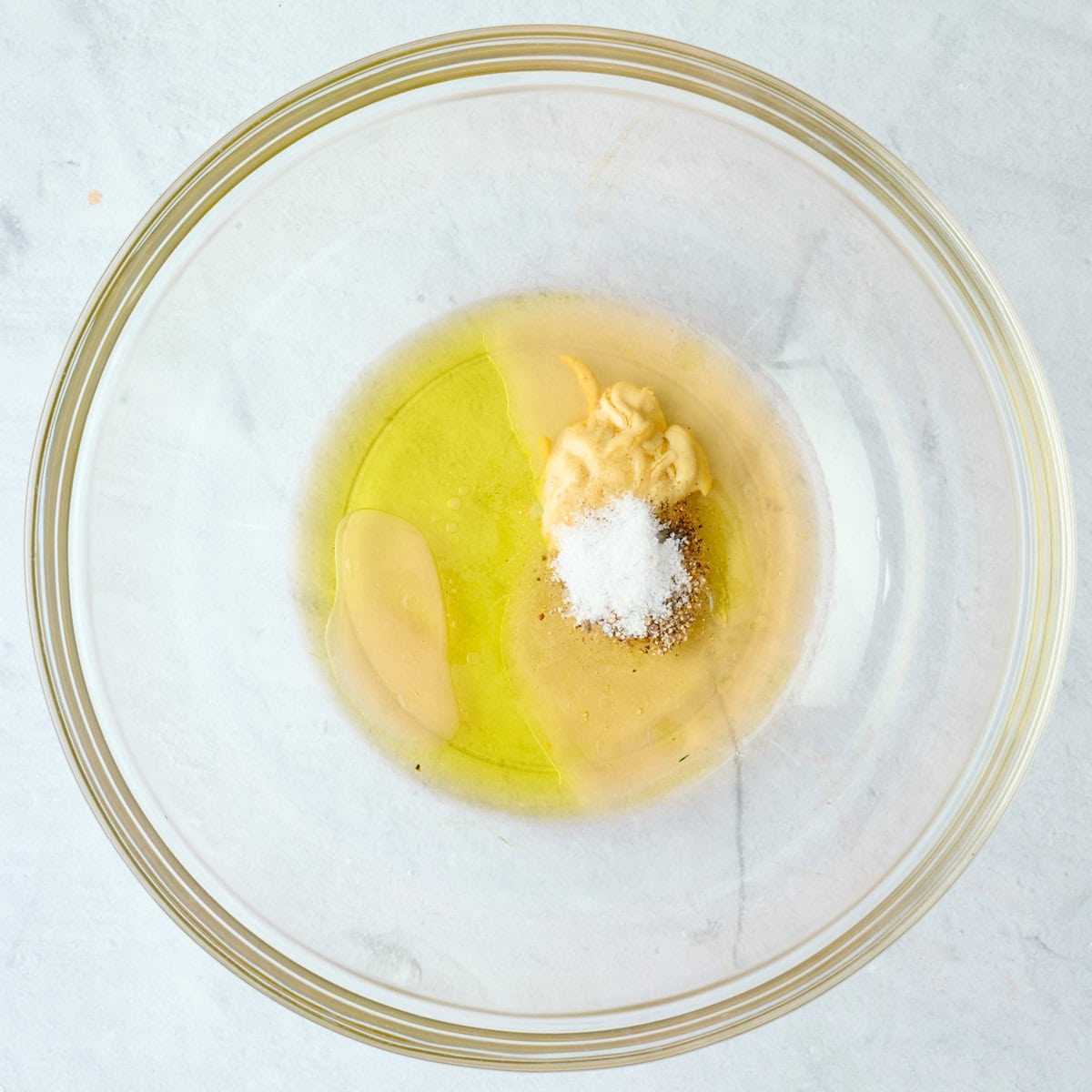 Dijon mustard, apple cider vinegar, olive oil, honey, salt and pepper in a small bowl before whisking together to make dressing for bean salad.