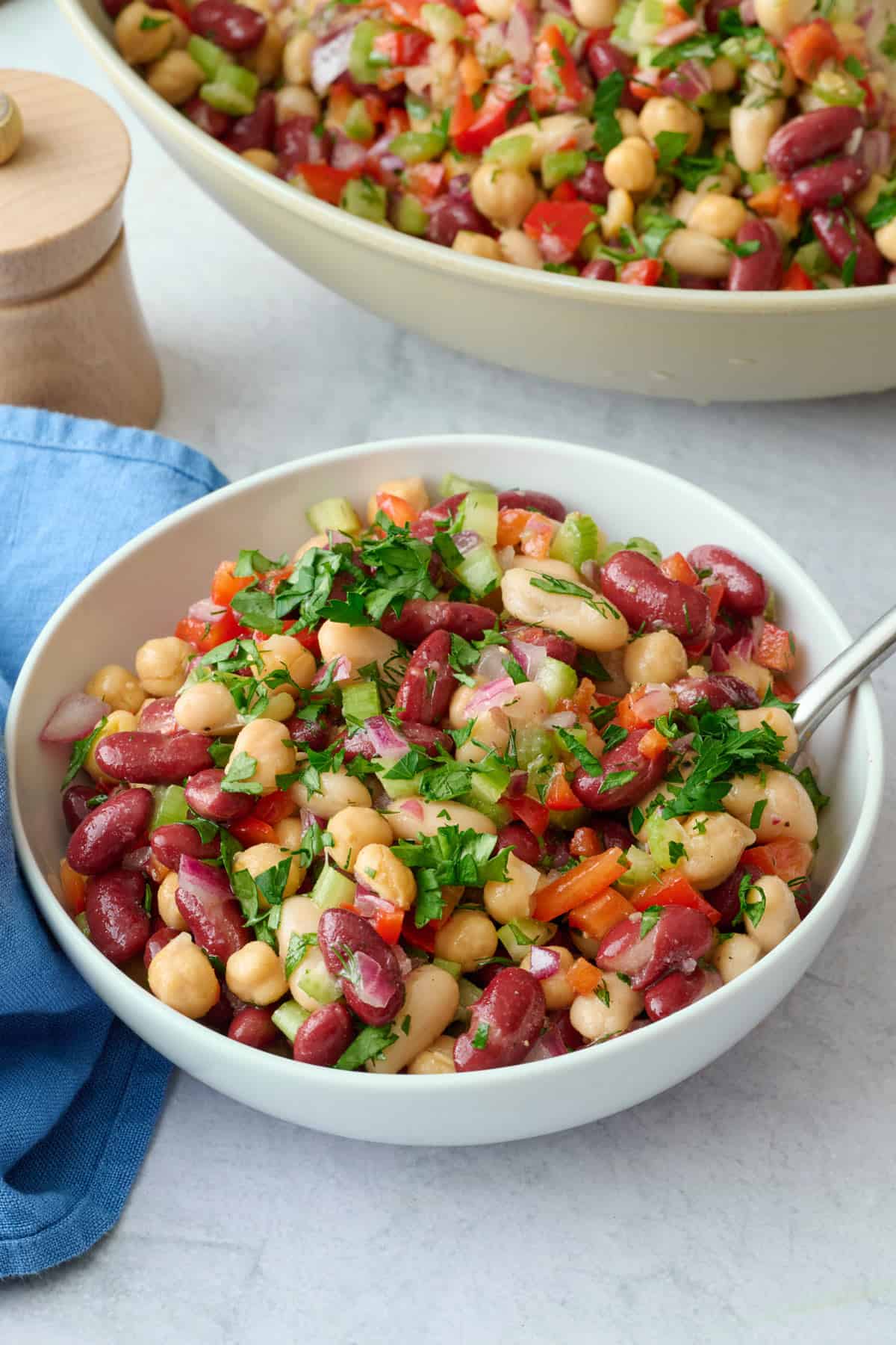 Serving of three bean salad made with kidney beans, cannellini beans, and chickpeas tossed in an easy dressing.