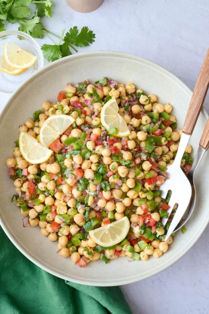 Quick and easy balela salad recipe in a serving dish, made with chickpeas, fresh herbs and veggies, and a zesty dressing.