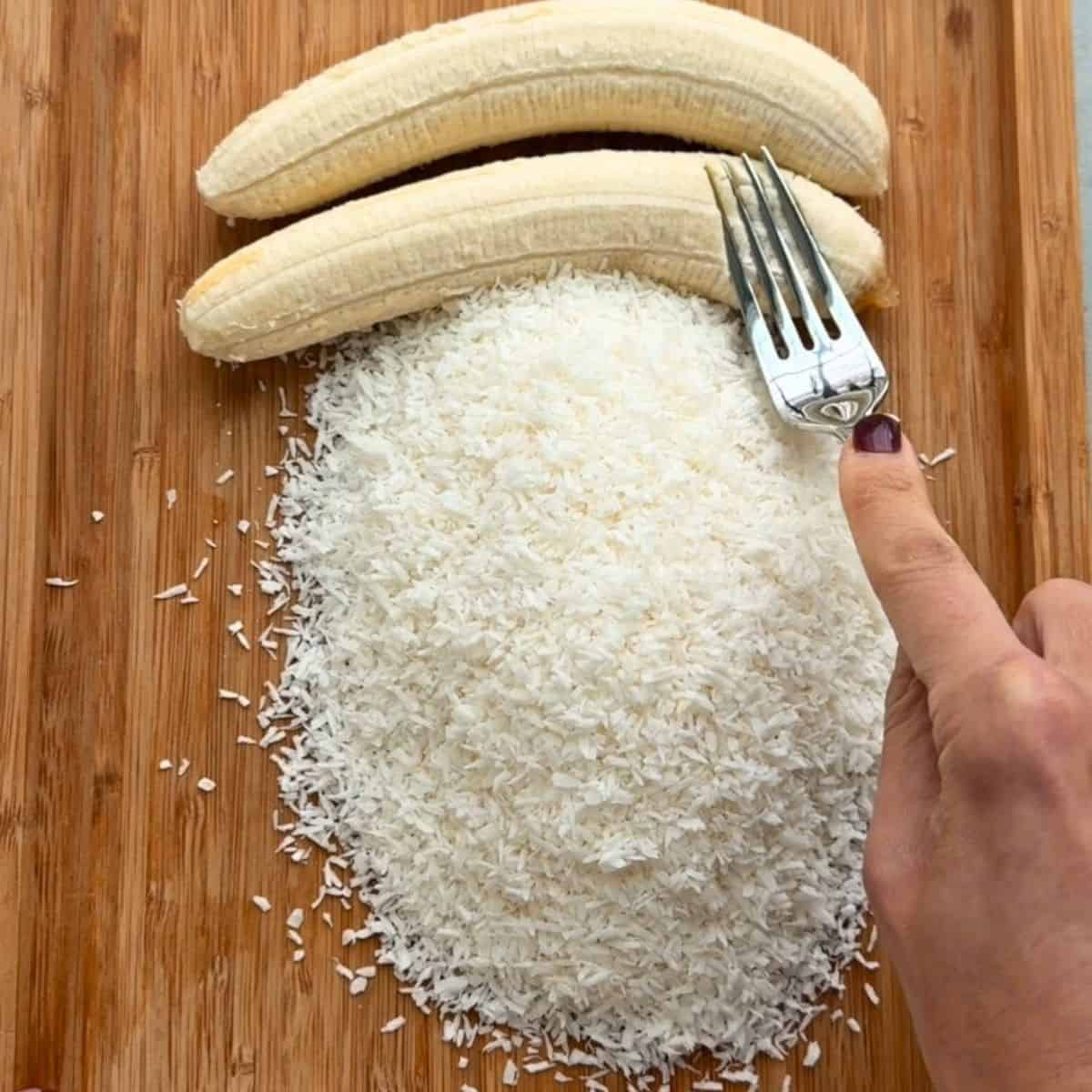 Bananas and shredded coconut on a cutting board before mashing together.
