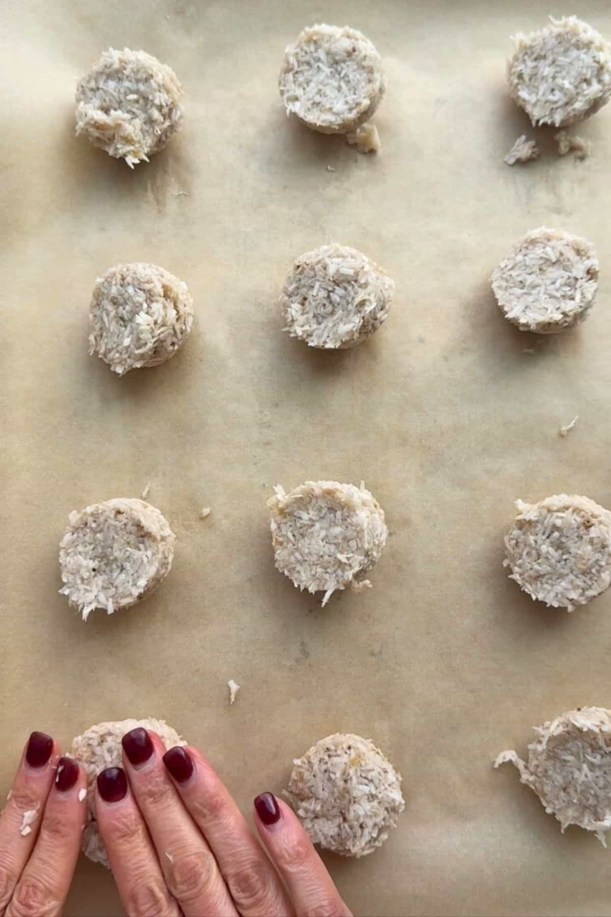 12 banana coconut cookie dough balls on a sheet pan before pressing flat.