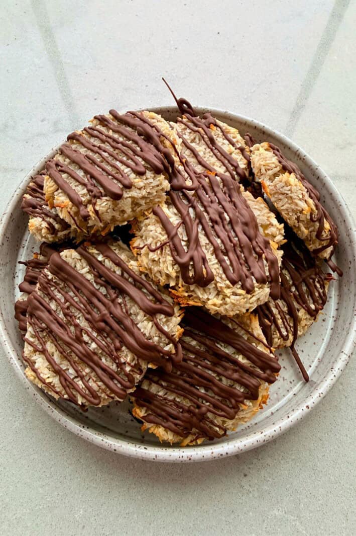 Viral 2 ingredient banana coconut cookies topped with a chocolate drizzle.