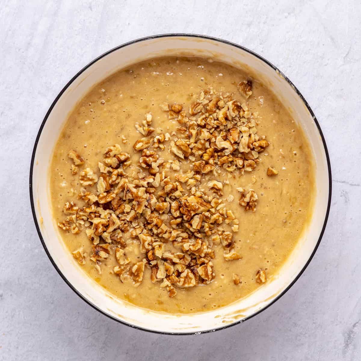 Muffin batter after combining wet and dry ingredients with chopped walnuts added before folding in.