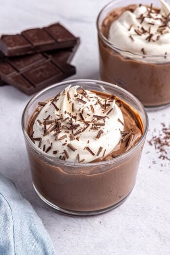Homemade boiled egg chocolate pudding recipe served in small glasses and topped with whipped cream and chocolate shavings.