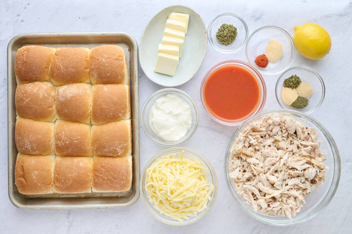 Ingredients for slider recipe: butter, yogurt, hot sauce, shredded cheese, seasonings, cooked shredded chicken and lemon.