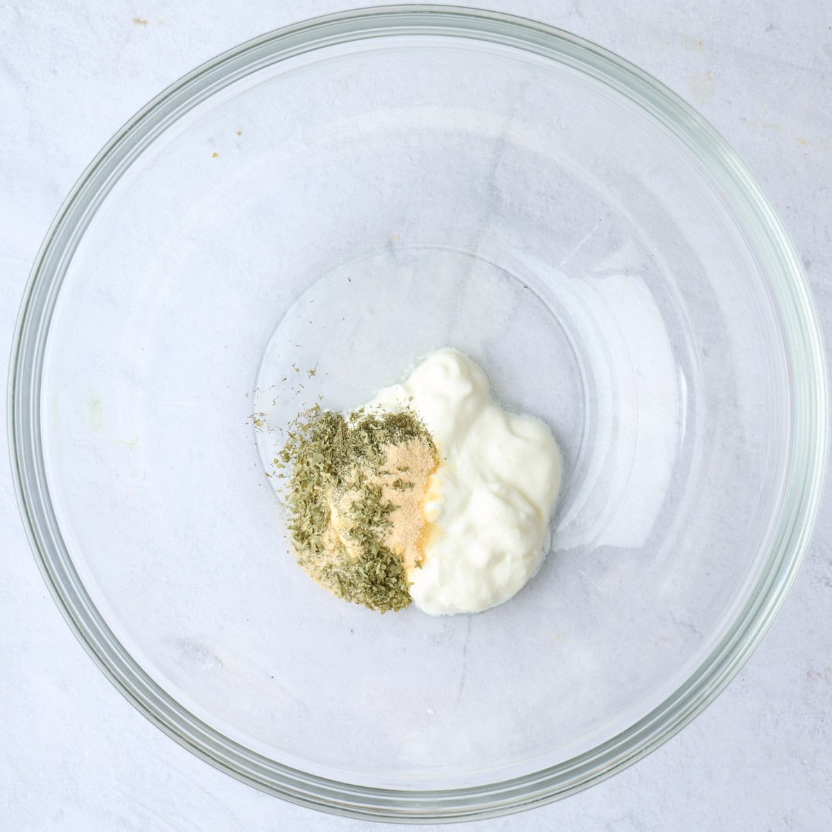Yogurt ranch ingredients in a bowl before mixing.