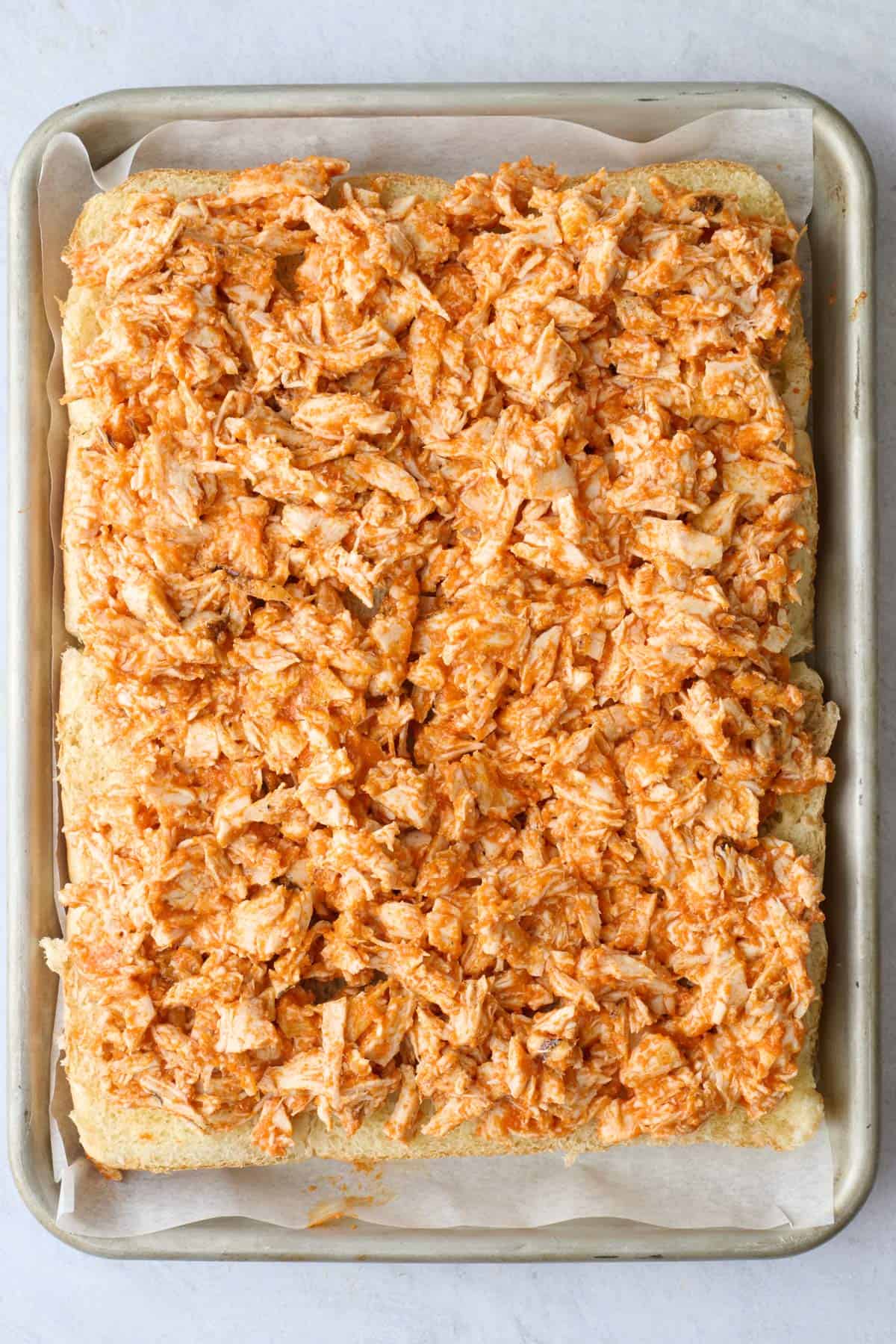 Buffalo chicken mixture spread evenly over prepared bottom buns.