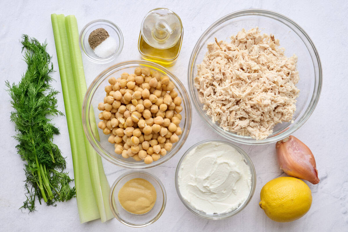 Ingredients for cold salad recipe: shredded chicken, chickpeas, oil, salt and pepper, celery, dill, Dijon mustard, Greek yogurt, lemon and shallot.