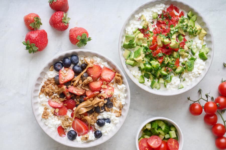 Two cottage cheese bowls, one with savory toppings including chopped veggies, herbs, salt and pepper. The other bowl with sweet toppings including fresh fruit, granola, and peanut butter.