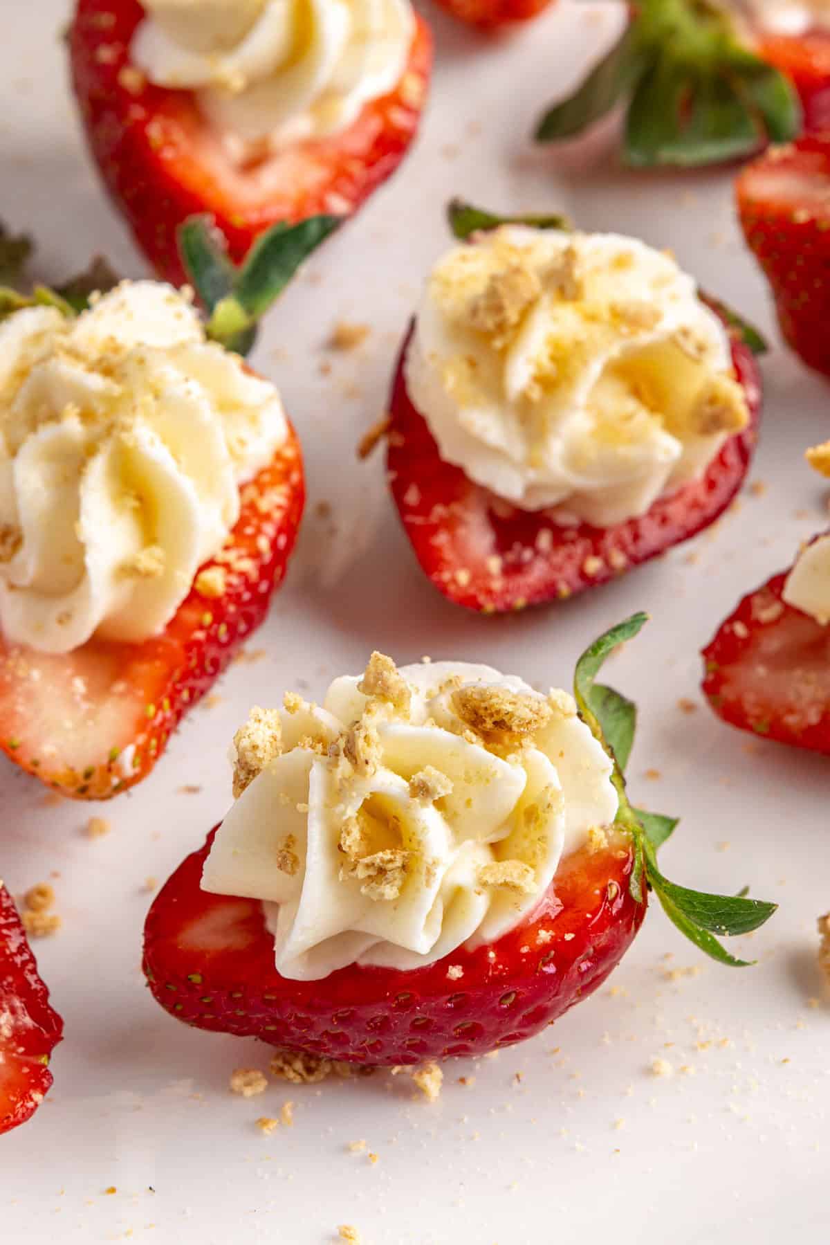 Best deviled strawberries filled with no bake cheesecake and topped with graham crackers.