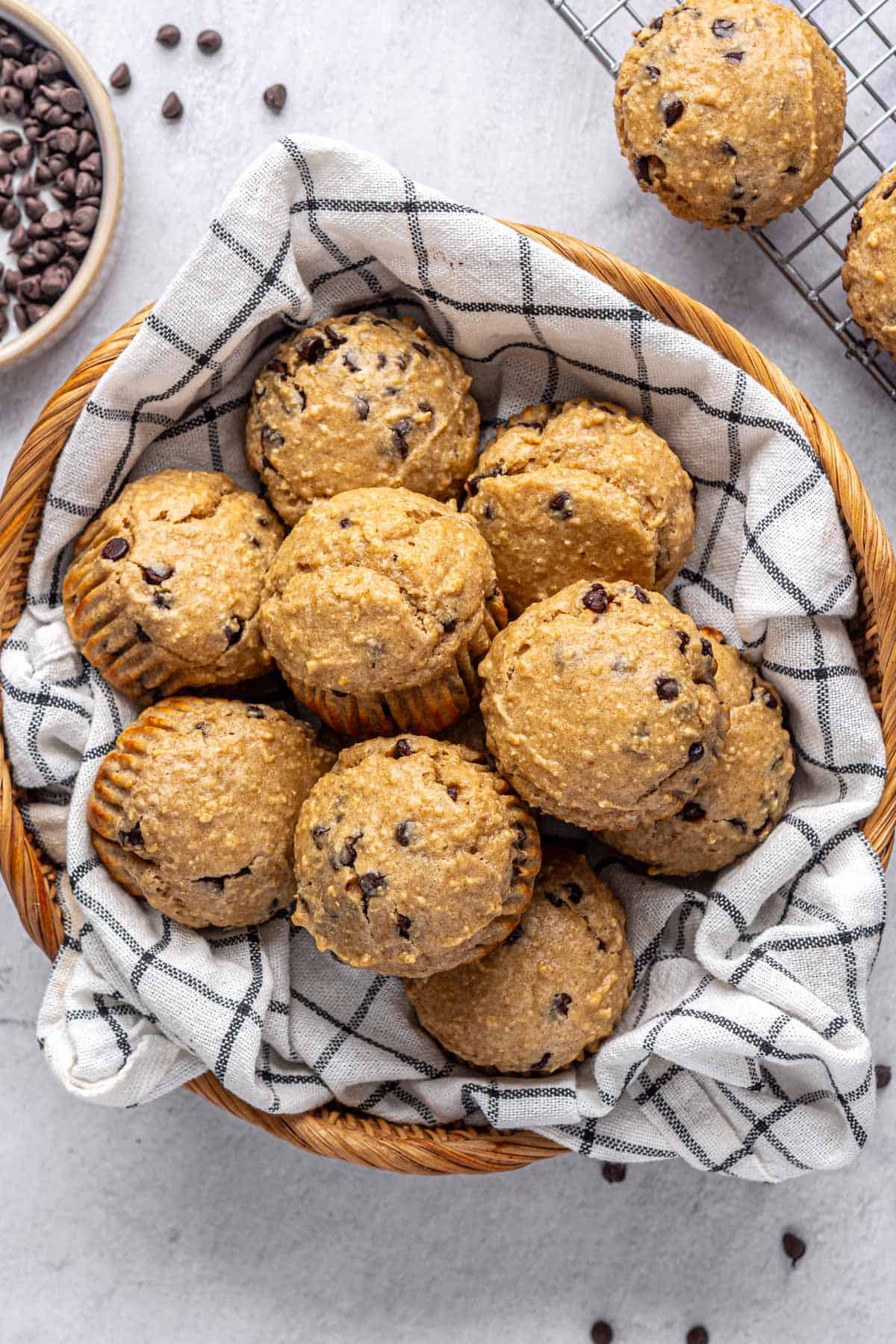 Best high protein muffins recipe in a basket with extra chocolate chips nearby.