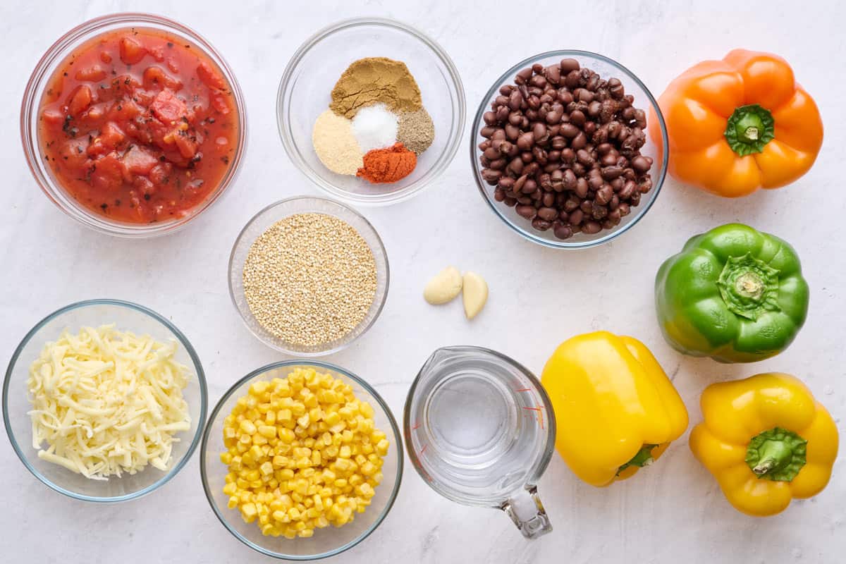 Ingredients for vegetarian stuffed pepper recipe: fire roasted diced tomatoes, cheese, quinoa, corn, seasoning blend, garlic, black beans, and bell peppers.