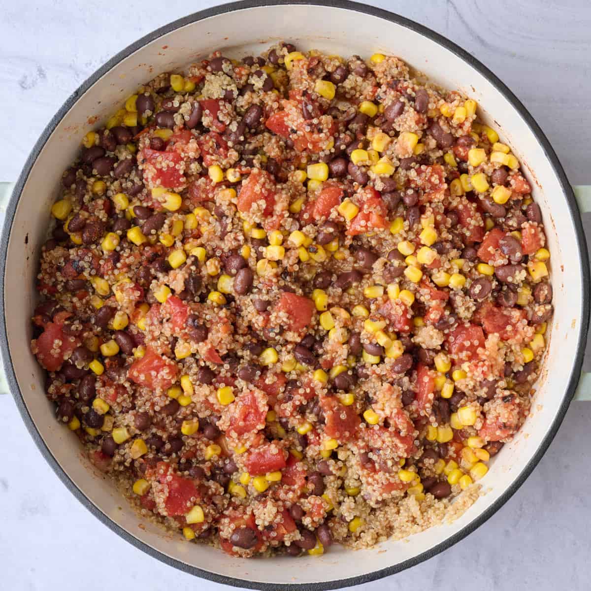 Vegetarian stuffed pepper filling with quinoa, corn and beans after tossing together in skillet.