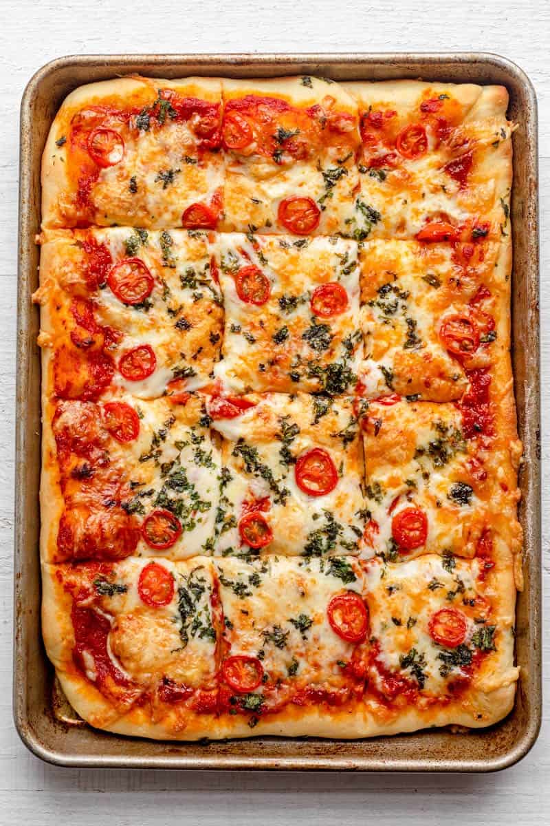 Pizza after baking on sheet pan and cut into 12 squares.